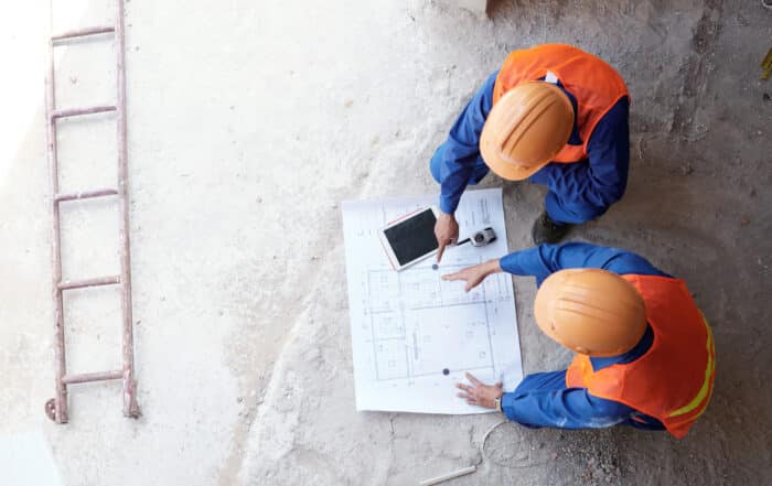 Contractor showing his employee blueprint of apartment, view from above