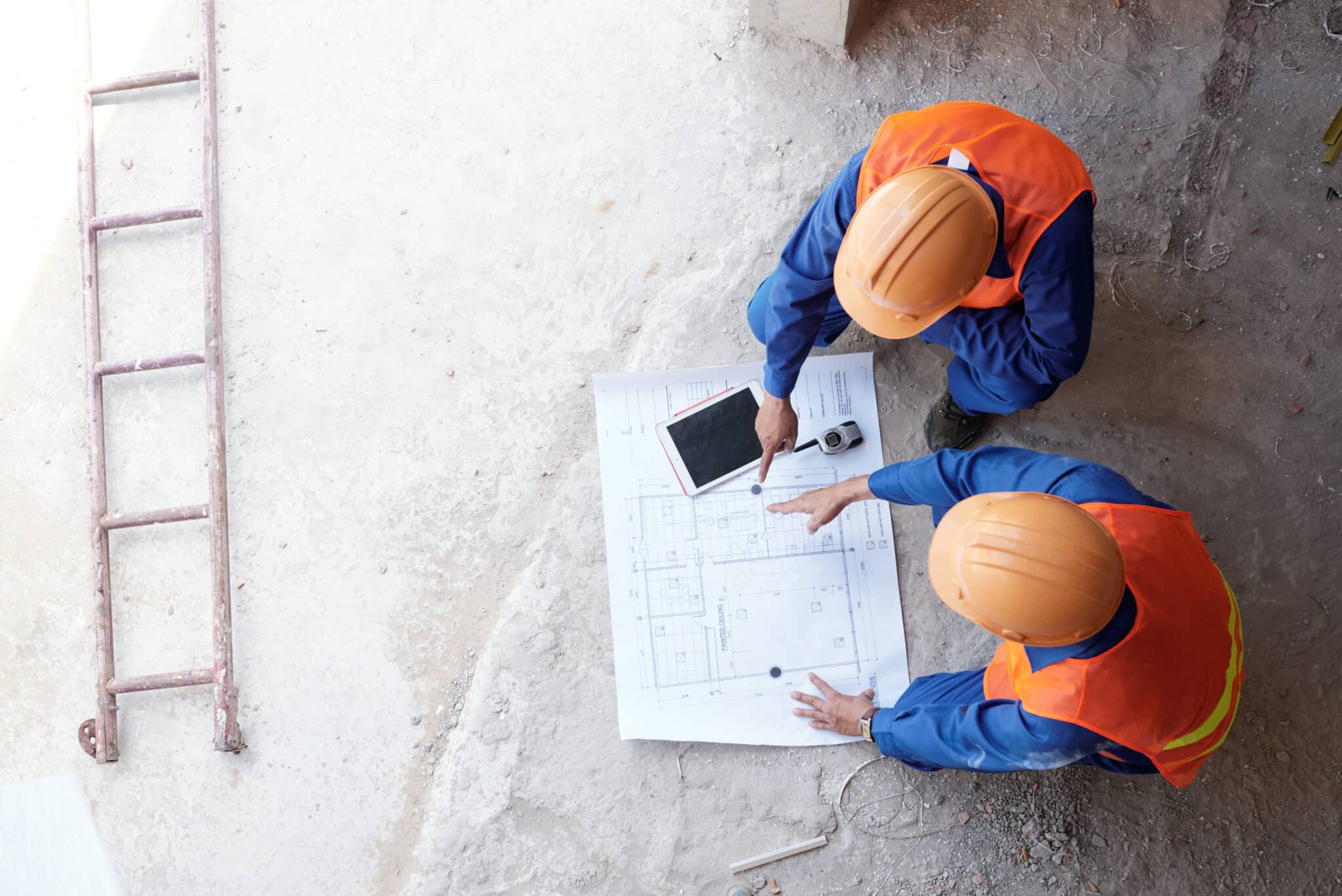 Contractor showing his employee blueprint of apartment, view from above